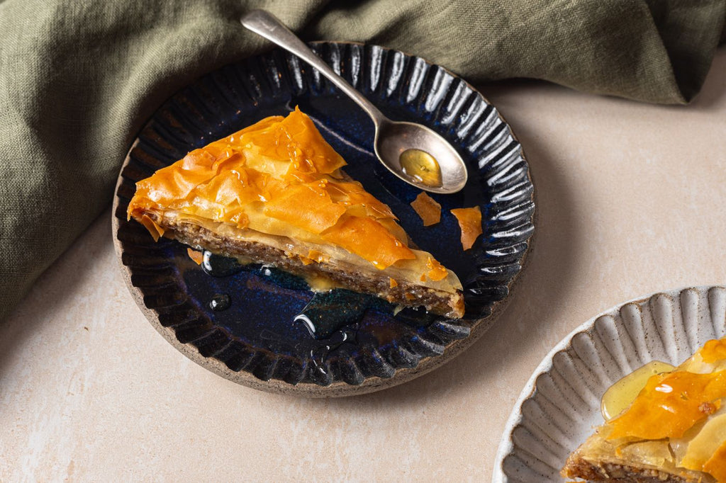A slice of Zymi baklava on a blue plate